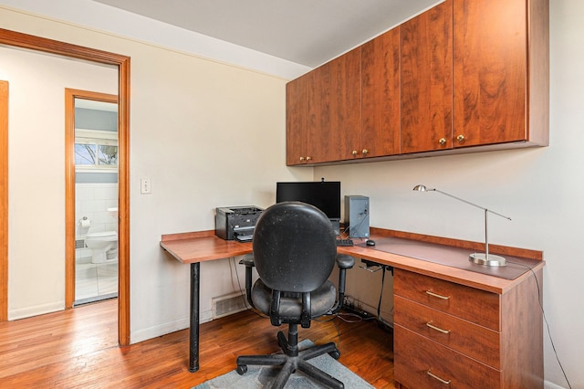 office space with baseboards and wood-type flooring