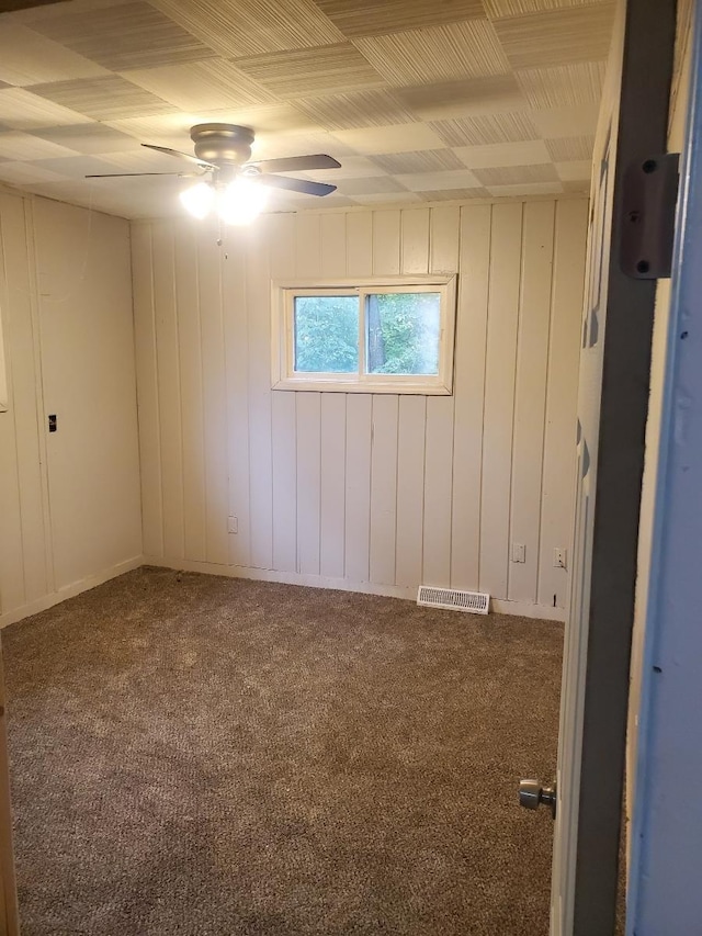 carpeted spare room featuring a ceiling fan and visible vents