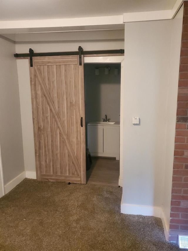 interior space featuring a barn door, visible vents, and baseboards