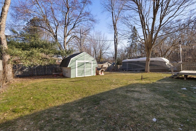 view of yard featuring a storage unit, an outbuilding, and a fenced backyard