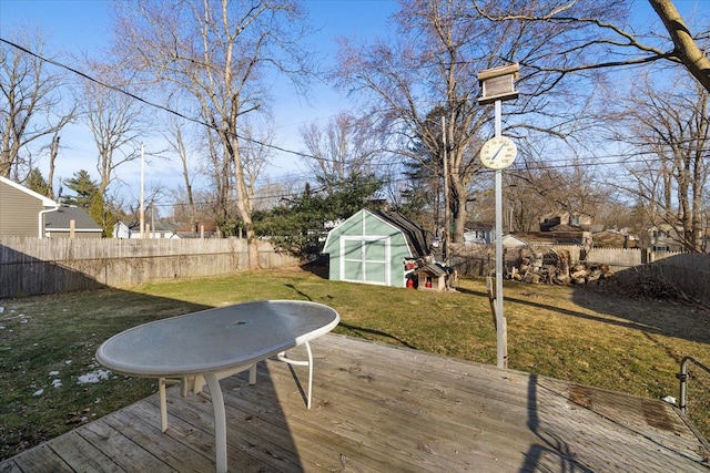 deck featuring a yard, a fenced backyard, a storage unit, and an outdoor structure