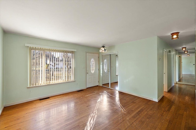 foyer entrance featuring visible vents, baseboards, and hardwood / wood-style flooring