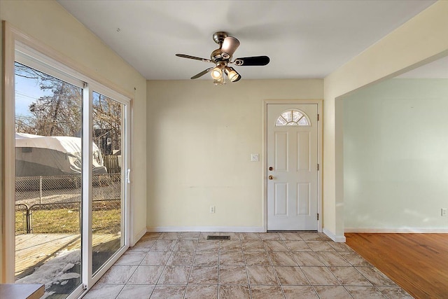 foyer entrance featuring plenty of natural light, visible vents, baseboards, and a ceiling fan