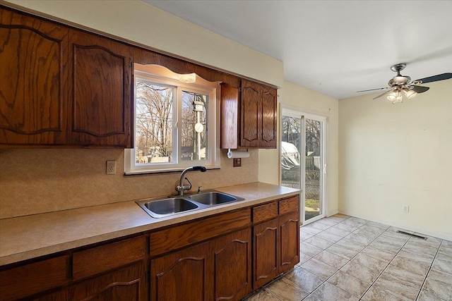 kitchen featuring a sink, visible vents, a ceiling fan, and light countertops