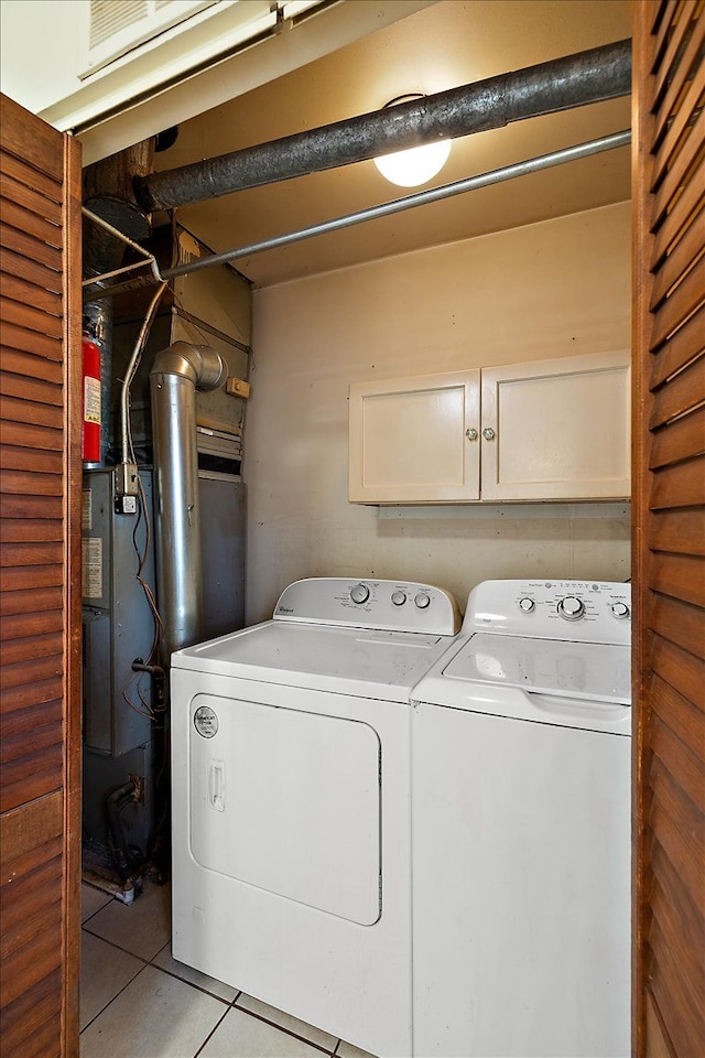 washroom featuring tile patterned flooring, cabinet space, and independent washer and dryer