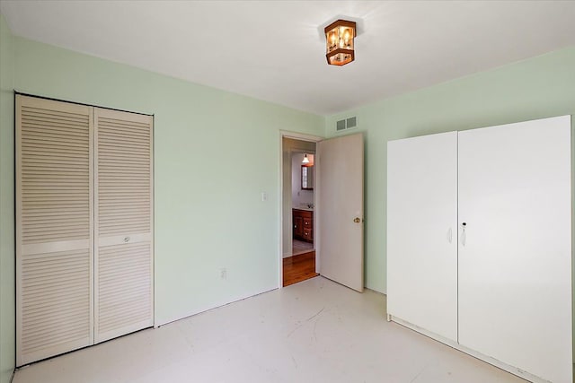 unfurnished bedroom featuring a closet, visible vents, and finished concrete floors