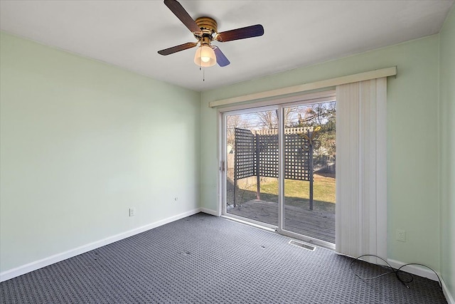 carpeted empty room featuring visible vents, a ceiling fan, and baseboards