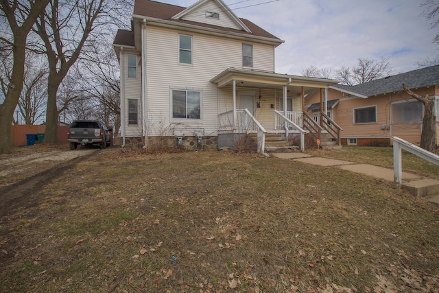 view of front of house featuring covered porch, dirt driveway, and a front yard