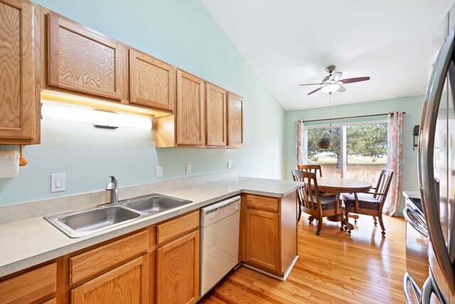 kitchen with light wood-style floors, stainless steel appliances, a sink, and light countertops