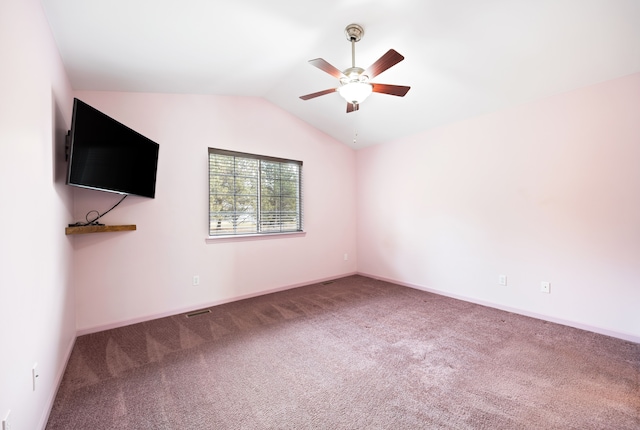 carpeted empty room featuring visible vents, vaulted ceiling, baseboards, and ceiling fan