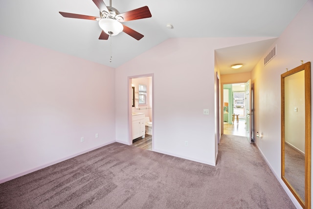 unfurnished bedroom featuring visible vents, baseboards, vaulted ceiling, carpet, and ensuite bath