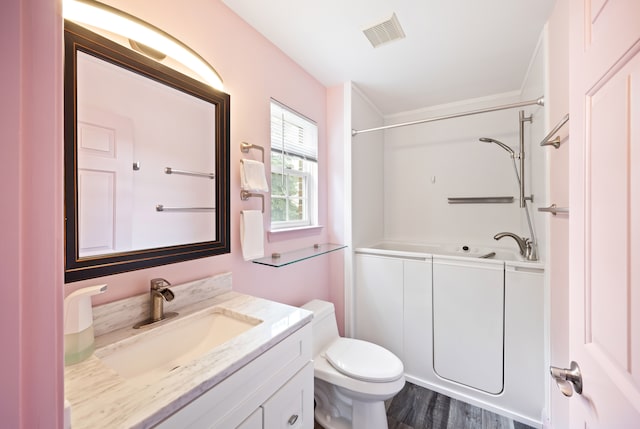 bathroom with visible vents, vanity, toilet, and wood finished floors