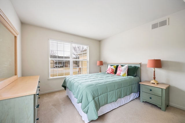 bedroom featuring baseboards, visible vents, and light colored carpet