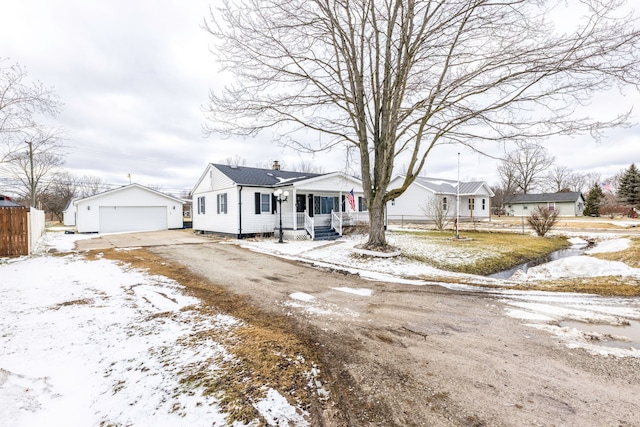 bungalow-style home with a porch, an outdoor structure, fence, a detached garage, and a chimney