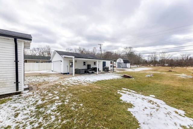 view of yard featuring a garage, an outdoor structure, and fence