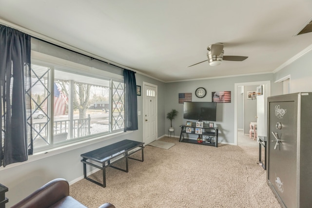 living room with baseboards, carpet, a ceiling fan, and crown molding