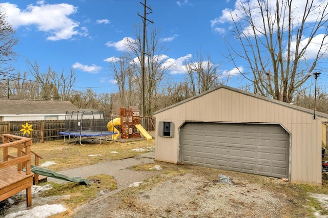 detached garage with a trampoline and fence