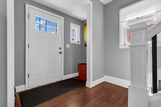 entrance foyer with dark wood-style floors and baseboards