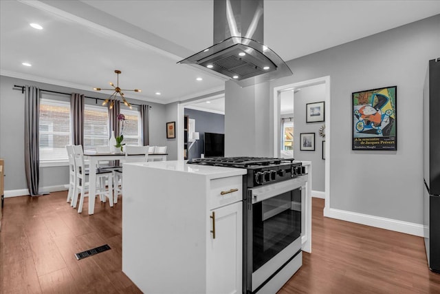 kitchen featuring dark wood-style floors, gas stove, island exhaust hood, and crown molding