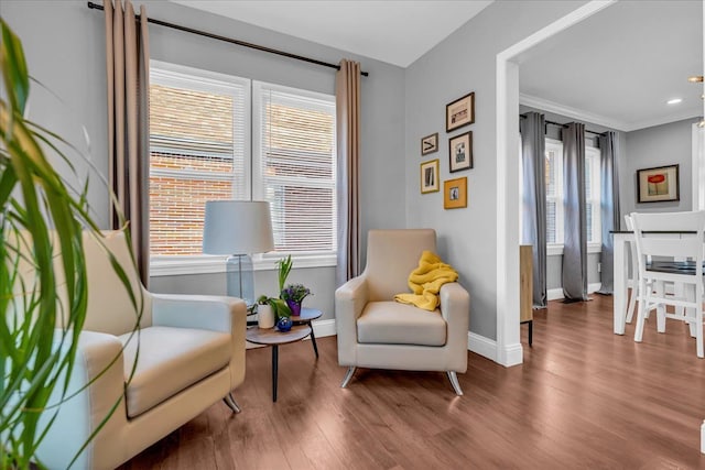 sitting room with recessed lighting, baseboards, wood finished floors, and ornamental molding