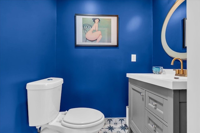 bathroom with vanity, toilet, and baseboards