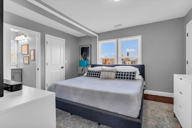 bedroom with visible vents, multiple windows, baseboards, and wood finished floors