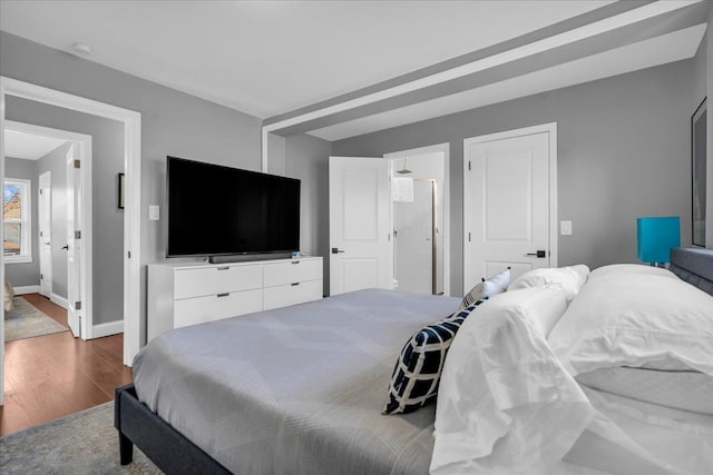 bedroom featuring baseboards and wood finished floors