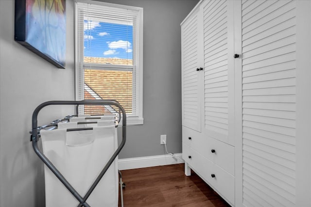 workout room with baseboards and dark wood-style floors