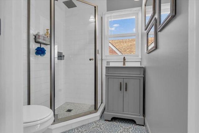 full bath with baseboards, toilet, a shower stall, and tile patterned flooring