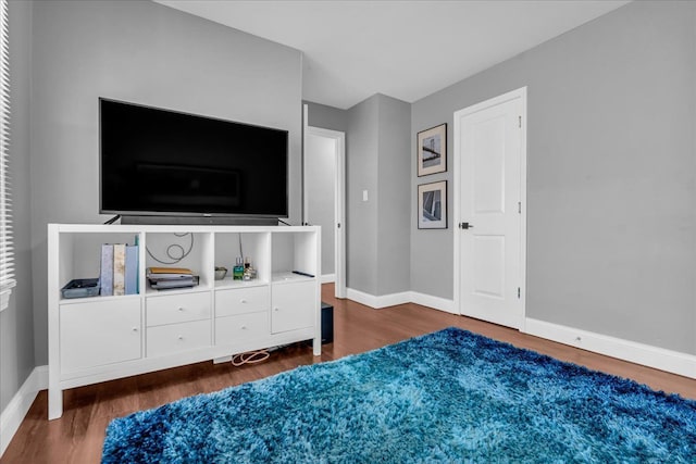 bedroom with baseboards and wood finished floors