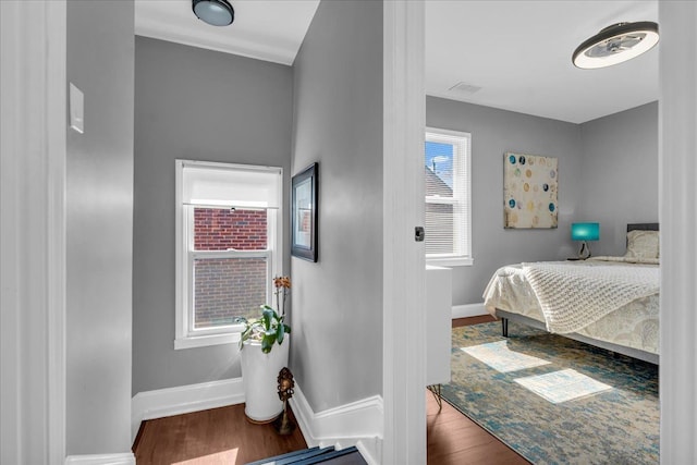 bedroom featuring visible vents, wood finished floors, and baseboards