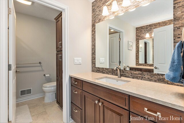 bathroom with toilet, visible vents, decorative backsplash, and vanity