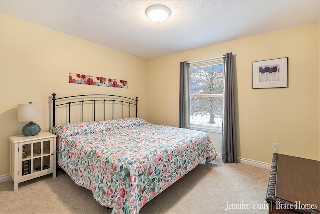 bedroom featuring light colored carpet, a textured ceiling, and baseboards