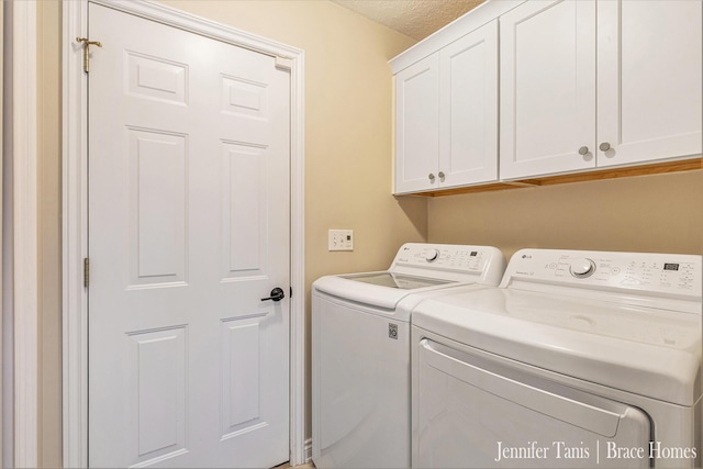 laundry room featuring cabinet space, separate washer and dryer, and a textured ceiling