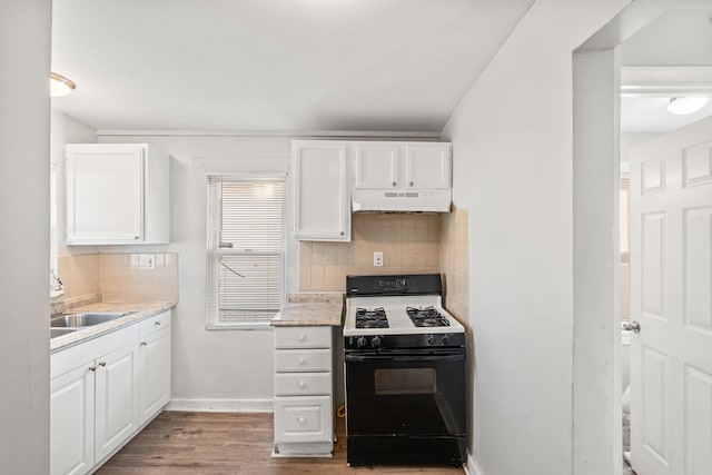 kitchen with black gas range, white cabinets, a sink, wood finished floors, and under cabinet range hood