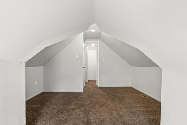 bonus room with carpet flooring and vaulted ceiling