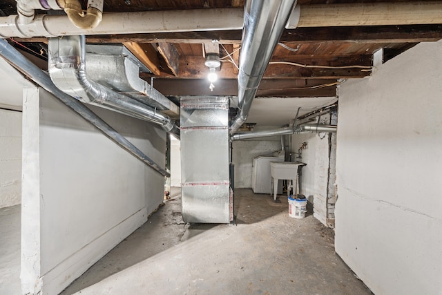 unfinished basement with a sink and heating unit