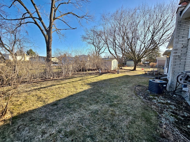 view of yard with a storage shed, an outdoor structure, and central air condition unit