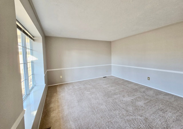 spare room featuring baseboards, carpet floors, and a textured ceiling