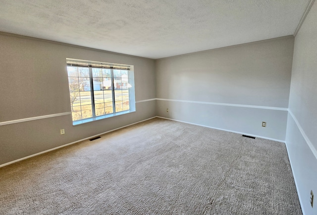 unfurnished room featuring visible vents, baseboards, a textured ceiling, and carpet