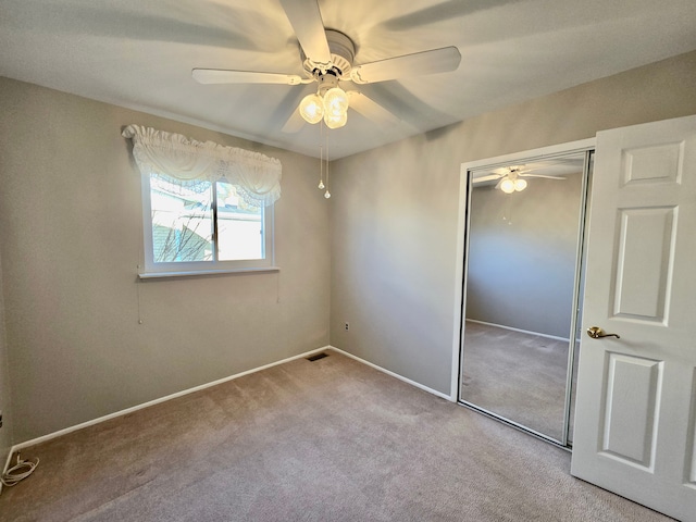 unfurnished bedroom with visible vents, a closet, carpet flooring, baseboards, and ceiling fan