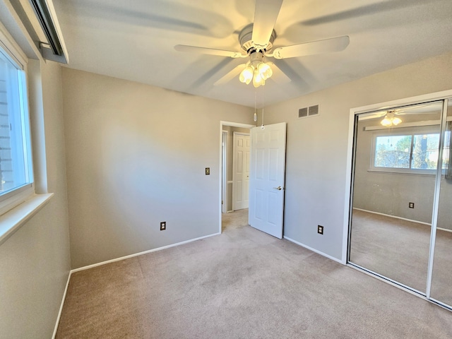 unfurnished bedroom featuring visible vents, baseboards, carpet flooring, a closet, and a ceiling fan