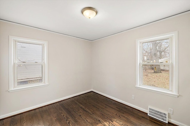 spare room featuring baseboards, visible vents, and dark wood-type flooring