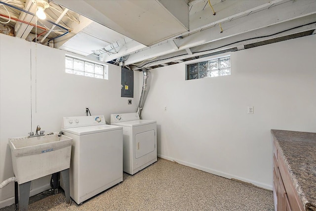 clothes washing area with washer and dryer, electric panel, a sink, and baseboards