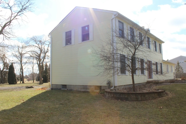 view of side of home featuring a lawn and driveway