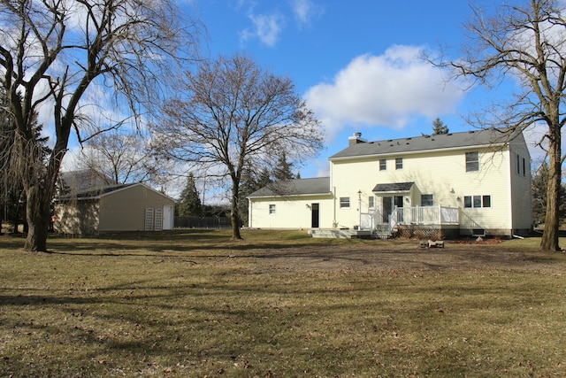 rear view of house featuring a deck, a yard, and a chimney