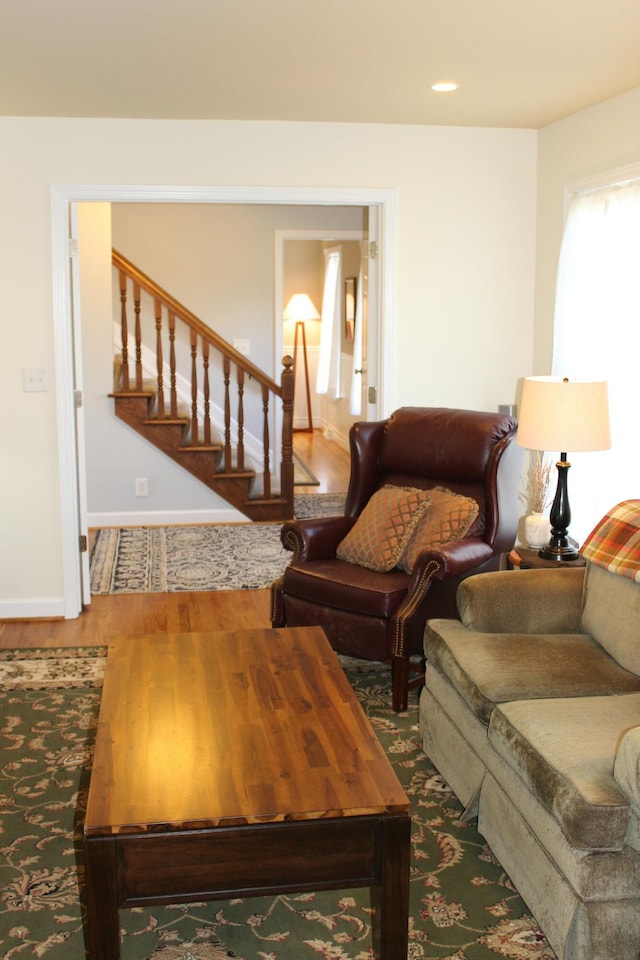 living area with stairway, recessed lighting, wood finished floors, and baseboards