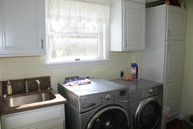 clothes washing area featuring a sink, cabinet space, and washer and clothes dryer