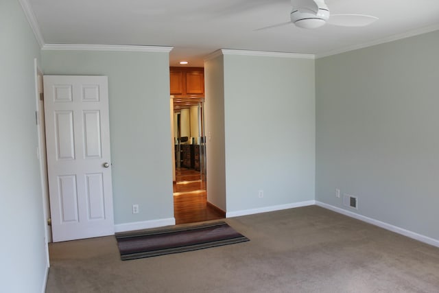 unfurnished room with visible vents, crown molding, ceiling fan, baseboards, and carpet floors