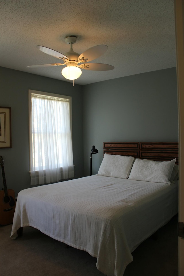 bedroom featuring ceiling fan and a textured ceiling